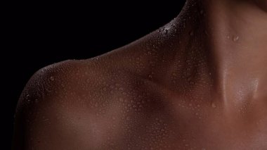 Deri dokusu ve vücut bakımı yaratıcı konsepti. Çekici bir modelin portresi. Çekici kadın modelin stüdyo, omuz ve köprücük kemiği bölgesindeki su damlalarındaki deri parçalarının yakın çekimi..