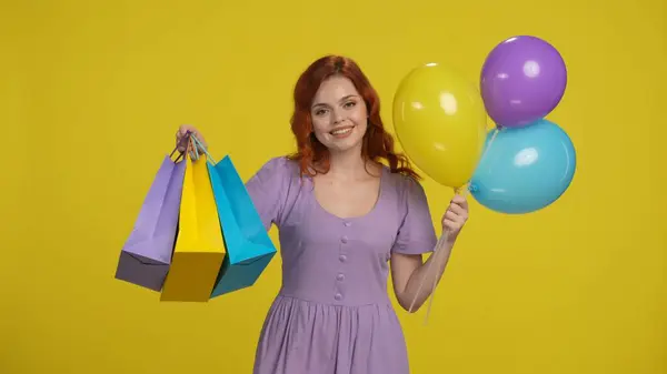 Radosna Rudowłosa Kobieta Torbami Zakupy Kolorowymi Balonami Kobieta Studio Żółtym — Zdjęcie stockowe