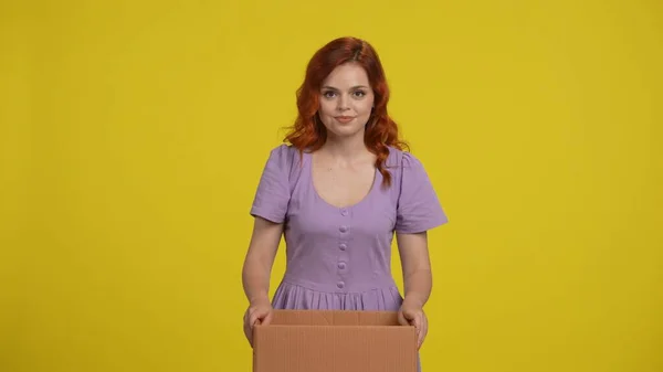 在网上商店快速购物 一个红头发的女人站在一家网上商店送来的纸板箱旁边 在工作室里的一个黄色背景的女人交付概念 — 图库照片