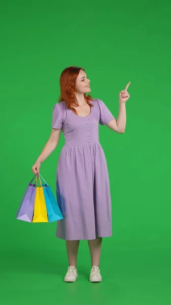 Uma Mulher Ruiva Com Sacos Compras Aponta Para Algo Com — Fotografia de Stock