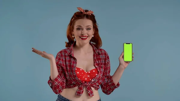 青い背景のフレームに明るい化粧をした若い女性 彼女はカメラを見て 緑色のスクリーンを持った携帯電話を持っている 驚きと喜びを表現する ここにあなたの広告 プロダクトである場合もあります Hdrについて — ストック写真