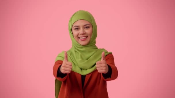 中等尺寸的独立录像拍摄了一个戴着头巾 头戴面纱的年轻貌美女子 她正在放弃大拇指 推荐这种产品 你的广告 促销的地方 — 图库视频影像