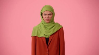 Orta ölçekli izole bir video, tesettür ve duvak takan çekici bir genç kadını çekiyor. Tiksinti ve tiksinti içinde başını sallıyor. Reklamınıza, kültürünüze, çeşitliliğinize yer.