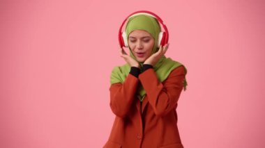 Orta ölçekli izole bir video, tesettür ve duvak takan çekici bir genç kadını çekiyor. O, kulaklıklar ve dansla enerjik müzik dinliyor. Reklam, kültür ve çeşitliliğe yer.