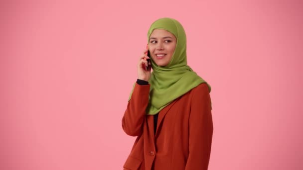 中等尺寸的独立录像拍摄了一个戴着头巾 头戴面纱的年轻貌美女子 她在讲电话 开心地微笑着 你的广告 多样性的地方 — 图库视频影像