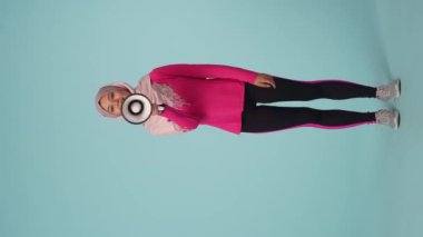 Tam ölçekli izole bir video, spor giyimli ve tesettürlü çekici bir genç kadın, Sheila. Hoparlörden konuşuyor, hoparlör. Reklam için yer, promosyon, spor.