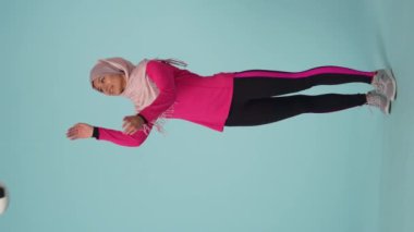 Tam ölçekli izole bir video, spor giyimli ve tesettürlü çekici bir genç kadın, Sheila. O bir futbol topunu tekmeliyor. Reklamınız için yer, modellik, promosyon, spor.