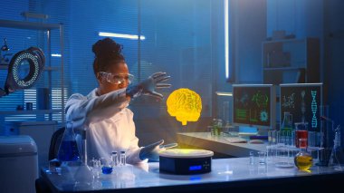 Medium-sized photo capturing a dark-skinned female scientist wearing glasses and a lab coat sitting in a laboratory, researching brain hologram. Advanced, innovation, augmented reality, science. clipart