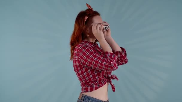 在一张蓝色背景的照片中 一个红头发的年轻女人 把太阳镜放在一边 把她的手掌放在脸上 她的目光转移到相机上 她笑了 顽皮的 甜蜜的 中视频 — 图库视频影像