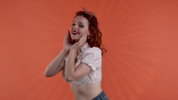 Kırmızı Arka Planda Parlak Makyajlı Kızıl Saçlı Genç Bir Kadın — Stok video