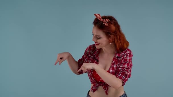 フレームには青い背景に明るい色のメイクを施した若い赤毛の少女が描かれている 彼女は見つめ 手を下ろしている ここにあなたの広告があります ミディアムビデオ — ストック動画