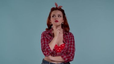 Mavi arkaplanda parlak makyajlı kızıl saçlı genç bir kadın var. Bir tarafa bakar ve bir şeyler düşünür, düşünür, rüya görür. Hoparlörler iki taraftan da ona doğrultulmuş..