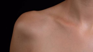 Deri dokusu ve vücut bakımı yaratıcı reklam konsepti. Çekici beyaz bir kadın modelin portresi. Genç kadın modelin yakın çekim stüdyosu parçası, köprücük kemiği omuz bölgesi pürüzsüz cilt.