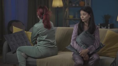 Bir odada kanepede pijama giyen iki genç kadının kavga ettikten sonra alındığını gösteren orta boy bir video. Kızlar birbirlerine dönüp sarılırlar. Kızlar gecesi, yatıya kalma, arkadaşlık, kardeşler.