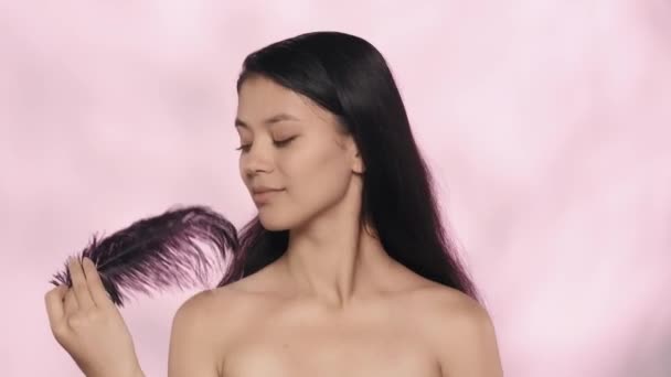 아름다움과 개념입니다 모델의 스튜디오 깃털을 그녀의 부드러운 피부를 만지는 카메라를 — 비디오