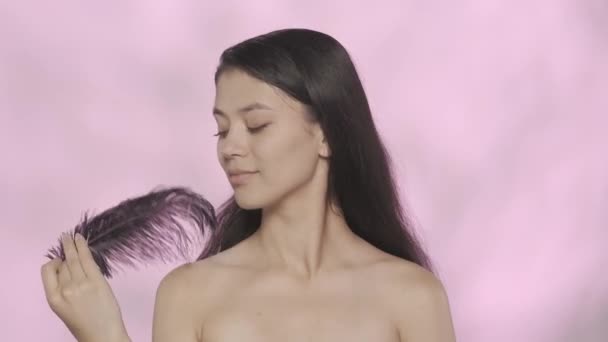 아름다움과 개념입니다 모델의 스튜디오 깃털을 그것으로 그녀의 부드러운 피부를 만지는 — 비디오