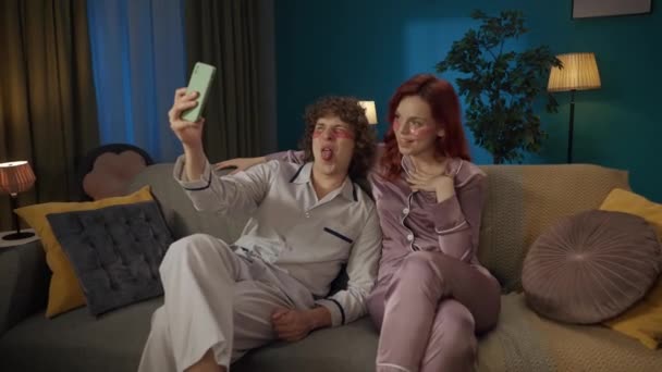 家庭和关系广告概念 一对年轻夫妇在一起度过时光的画像 男人和女人眼皮底下都戴着眼罩 在智能手机上装出一副微笑的样子 — 图库视频影像