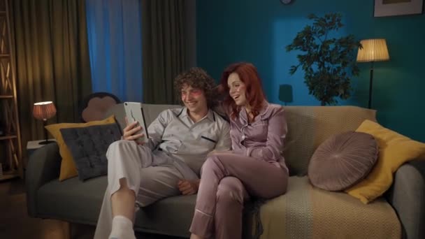 家族と人間関係の広告コンセプト 一緒に過ごした若いカップルの肖像画 タブレットのビデオ通話で話す 笑顔を着ているパジャマの男女 — ストック動画
