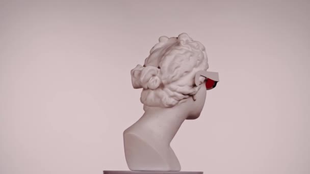 美しい古代の女神ヴィーナス大理石像のクローズアップショット プラットフォーム上で回転するロマン時代の女性バストの肖像画 ピンクの背景で孤立した クリエイティブな抽象概念 — ストック動画