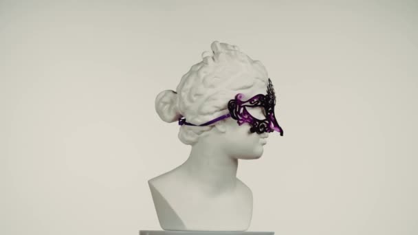 カーニバルアイマスクの美しい古代の女神金星大理石像のクローズアップショット ロマン時代の肖像画 プラトフォルムで回転する女性バスト 白い背景に孤立した クリエイティブな抽象概念 — ストック動画