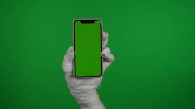 Detaylı yeşil ekran izole edilmiş krom anahtar videosu annelerin reklam alanı olan akıllı bir telefonu tutarken görüntüsü, çalışma alanı tanıtım videonuz veya reklamınız için maket yapın..