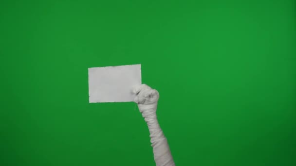 詳細緑色のスクリーンは 空白の紙を上げるママの手をキャプチャするクロマキービデオを分離しました あなたのプロモーション 広告のためのハロウィーン モックアップとバナー — ストック動画