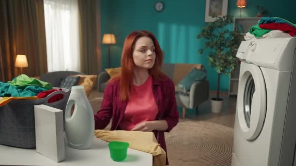 Kızıl Saçlı Kadın Çamaşır Makinesinin Yanında Oturuyor Bir Fincana Sıvı — Stok video