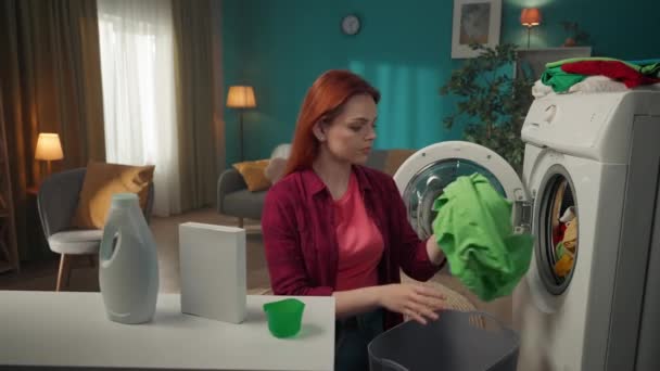 Çamaşır Makinesinin Yanında Duran Kızıl Saçlı Kadın Yıkanmayan Giysileri Boşaltıyor — Stok video