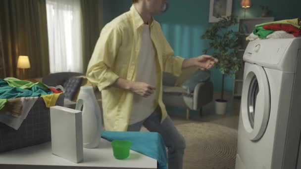 Koyu Renk Saçlı Bir Adam Çamaşır Makinesinin Yanında Oturuyor Bir — Stok video