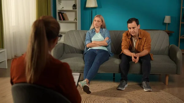 Spouses avoid talking after a marital argument, wife and husband sit on the couch in a marriage therapy session with a psychologist in the office. Marriage Therapy