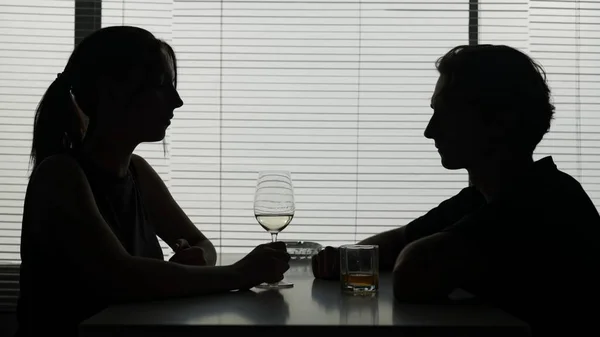 ショットでは 若い女性と男性がテーブルに座っています 彼らは 彼らが話し続けているアルコールを飲んだ後 話すことについて話します アルコール依存 ミディアムショット — ストック写真