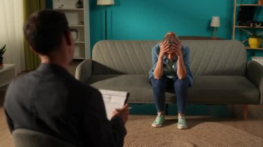 Mutsuz genç bir kadın, bir kanepede oturur, umutsuzlukla, bir terapistin önünde. Akıl sağlığı terapisi kavramı. Depresyon