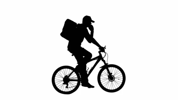 带背包冰箱的送货员的黑色侧影骑着一辆在白色背景阿尔法通道上的智能手机上说话的自行车 骑自行车在电话里聊天的男性骑手的画像 — 图库照片