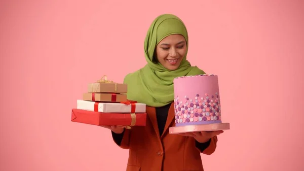 中サイズの孤立した写真は ヒジャーブ ベールを着た魅力的な若い女性を撮影します 彼女は贈り物とケーキを手に持っていて 興奮して幸せです 多様性のための場所 — ストック写真