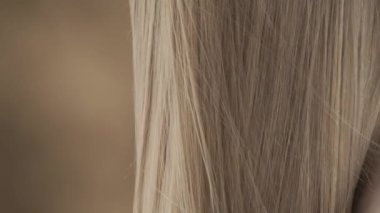 Güzel, genç bir kadının saçını yakından çek. Başını kaldırmış, rüzgar ona esiyor ve saçlarını geliştiriyor. Başını hafifçe eğiyor, kameraya bakıyor ve gülümsüyor.