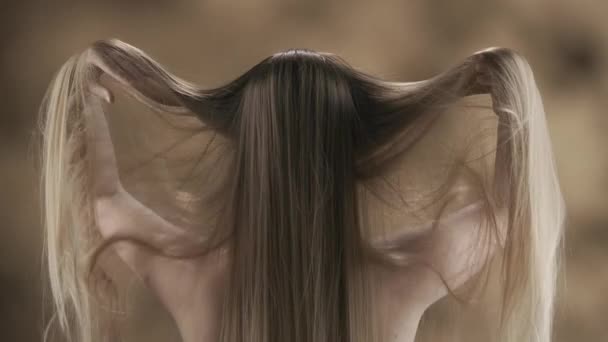 在一张特写的照片中 一个漂亮的年轻女子有着一头长长的金发 背景斑斑 她站在后面 双手甩着头发 它们慢慢地从她手中滑落 慢动作 Hdr — 图库视频影像