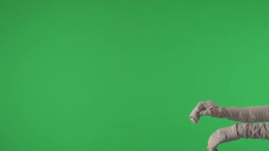 Yeşil ekran, bir mumyayı kolları açık bir şekilde çerçevenin bir tarafından diğer tarafına sendeleyerek çekerken gösteren krom anahtar videoyu izole etti. Model yapın, tanıtım videonuz ya da reklamınız için çalışma alanı.