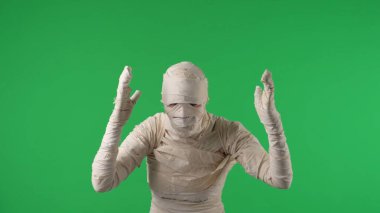 Yeşil ekran izole edilmiş krom anahtar fotoğraf bir mumyanın dans ediyormuş gibi kollarını sallarken, kafa karışıklığı gösterirken ya da dikkat çekerken. Model yapın, tanıtım videonuz ya da reklamınız için çalışma alanı.