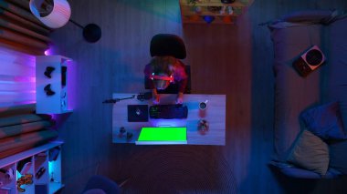 Oyun ve yayın konsepti. Kulaklıklı bir kadının odanın masasında oturup PC 'ye baktığı kahve içtiği, Chroma' nın yeşil ekranı ile izlediği, reklam alanının çalışma alanı modellemesi..