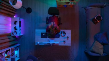 Çevrimiçi oyun reklam konsepti. Evde modern bilgisayar olan bir oda manzarası. İnternette bilgisayar izledikten sonra masa başında uyuyan günlük kıyafetli bir kızın en iyi görüntüsü..