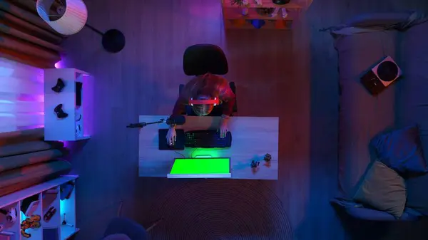 ゲームとストリーミングのコンセプト 部屋のストリーミングゲームで机に座っているヘッドフォンの女の子のトップビュー クロマキーグリーンスクリーン付きコンピュータ 広告エリアワークスペースモックアップ — ストック写真