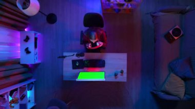 Oyun ve yayın reklam konsepti. Kulaklıklı bir kızın PC 'de Chroma tuşlu yeşil ekranla oyun oynaması, insanlarla online konuşması, reklam alanı çalışma alanı modellemesi.