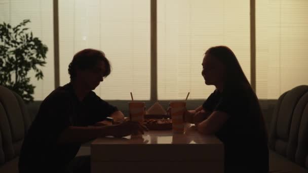 日常生活社会关系的轮廓概念 夫妇在自助餐厅的肖像 男人和女人坐在快餐店里聊天 吃披萨 在一起消磨时光 — 图库视频影像