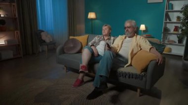 Çekimde, yaşlı bir çift bir dairede bir kanepede oturuyor. Sanki televizyondaymış gibi yan tarafa bakıyorlar. Bir film ya da dizi izlerler, beğenmezler, adam kanalı değiştirir. Hepsi bundan hoşlanıyor..
