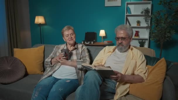 Dalam Gambar Pasangan Tua Duduk Sofa Apartemen Terhadap Dinding Biru — Stok Video
