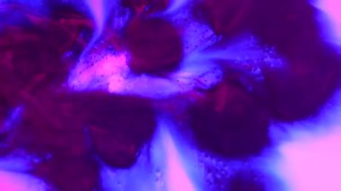 Su ve sıvı, yaratıcı ve soyut kavramları karıştırıyor. Su yüzeyinin yakın çekim stüdyosu. Rüzgârla esen mor mürekkep damlalarıyla dolu canlı renkli su yüzeyi, soyut bir arka plan. Yavaş çekim.