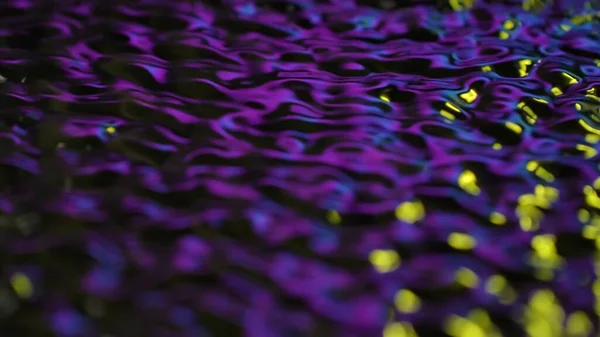 Water and light creative abstract advertisement concept. Close up shot of surface texture. Beautiful violet neon light water surface with ripples and waves, abstract background, wallpaper template.