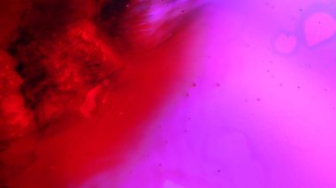 Su ve sıvı, yaratıcı ve soyut kavramları karıştırıyor. Su yüzeyinin yakın çekim stüdyosu. Parlak neon renkli mürekkep suda akıyor ve güzel canlı bir doku yaratıyor, soyut arka plan kağıdı..