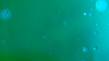 Su ve sıvı, yaratıcı ve soyut kavramları karıştırıyor. Su yüzeyinin yakın çekim stüdyosu. Mürekkep ve yağ damlaları ile koyu yeşil renkli su güzel dokuyu eşleştirir, soyut arkaplan kağıdı.