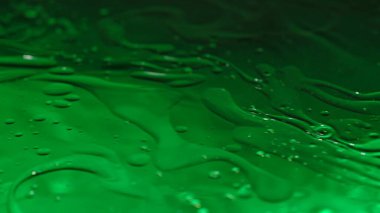 Su ve sıvı, yaratıcı ve soyut kavramları karıştırıyor. Su yüzeyinin yakın çekim stüdyosu. Mürekkep ve yağ damlalı yeşil renkli mermer su güzel bir geçişi, soyut bir duvar kağıdını eşleştirir.